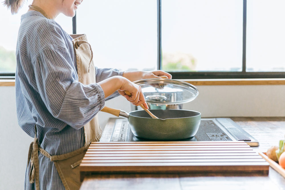 女性がフライパンで調理中