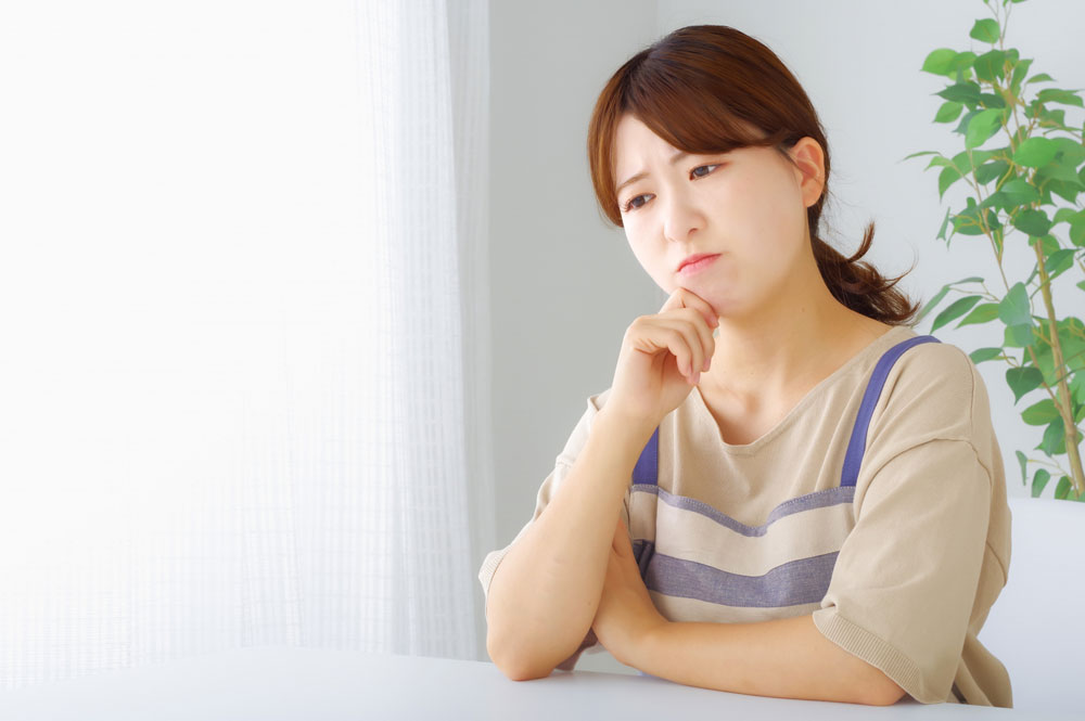 悩むエプロン姿の女性