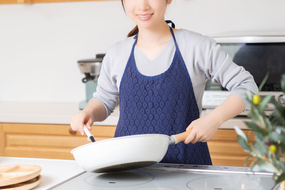 フライパンで焼く女性