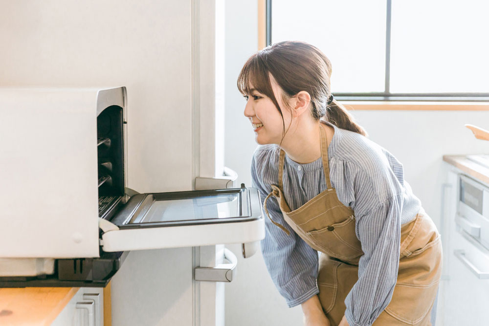 オーブンを覗く女性