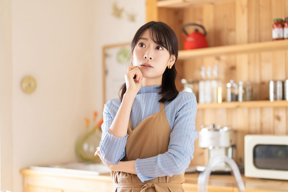 疑問に思うエプロン姿の女性